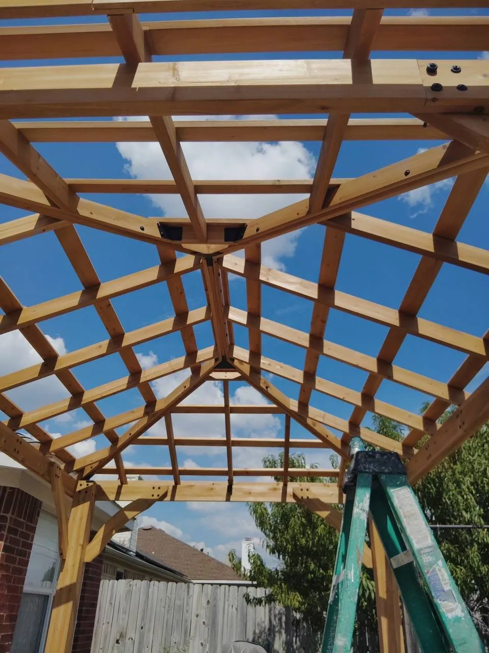 Cedar pergola roof framing seen from below during construction