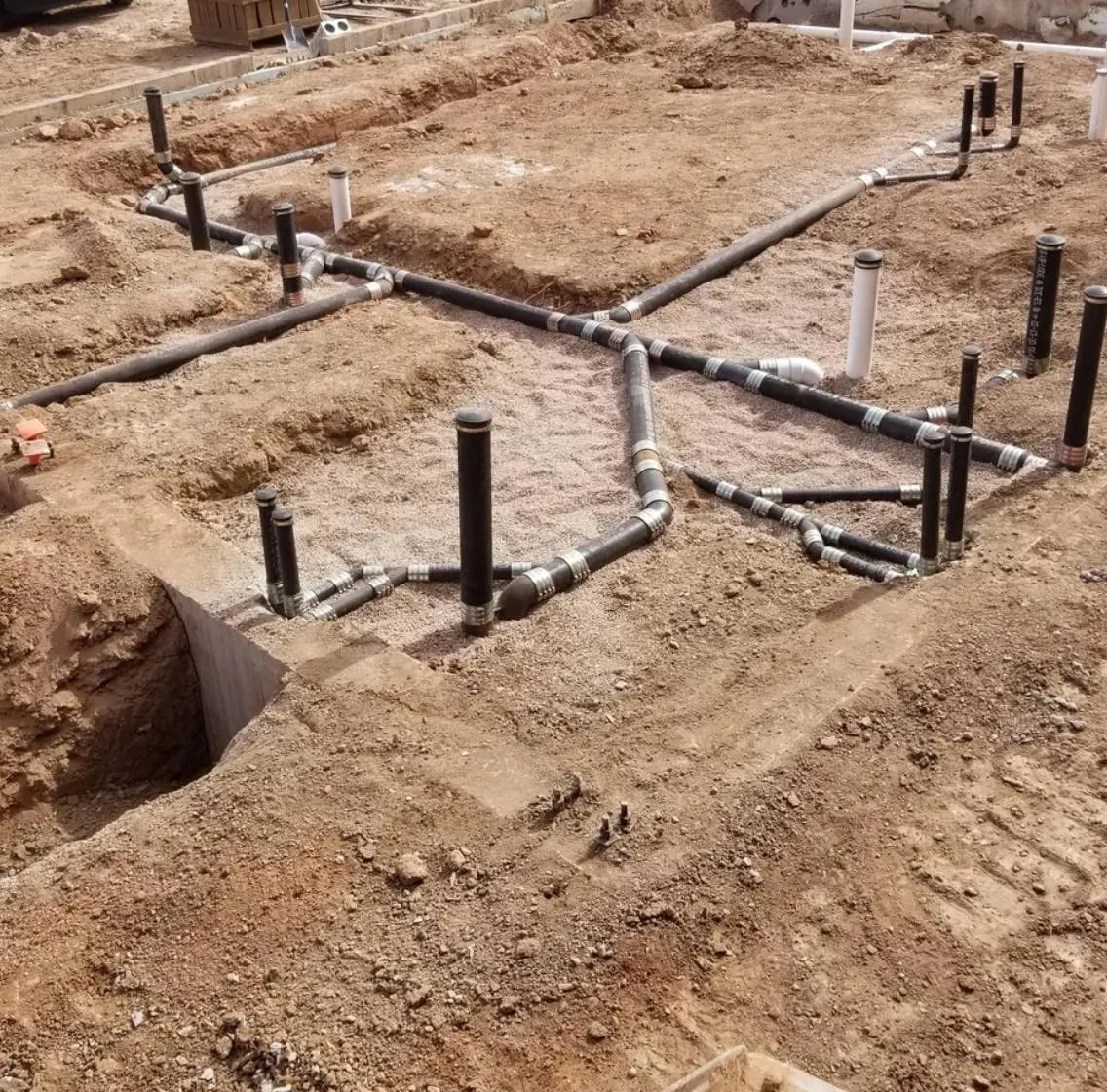 Under-slab drain lines laid in trenches before a foundation pour